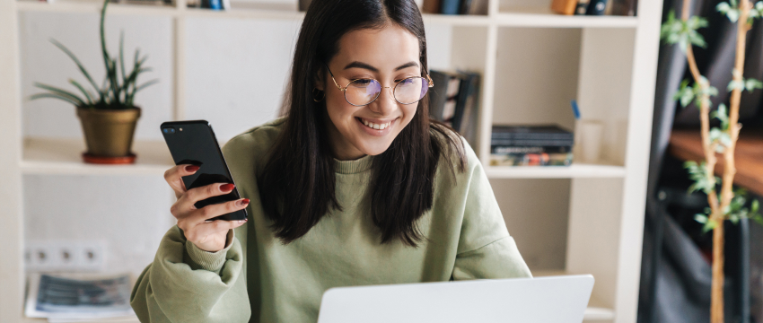 A successful woman monitoring live market charts on her laptop, illustrating a guide on the various types of traders, including day traders, swing traders, and scalpers.