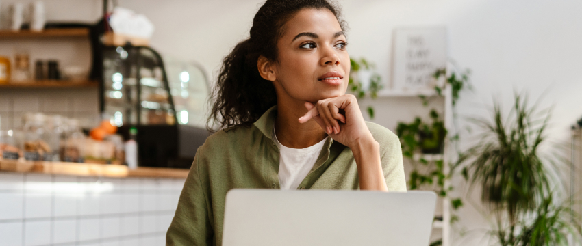 A focused woman analyzing currency charts on her computer to determine the best time to trade eurusd during overlapping market hours.