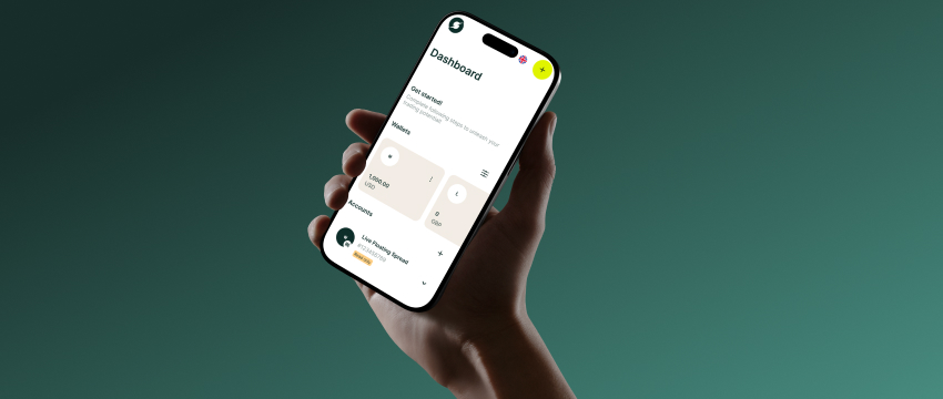 A person holding a smartphone displaying a financial mobile app dashboard with wallet balances, ideal for beginners learning what is trading and how to manage online accounts.