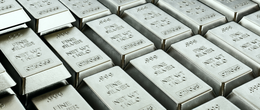Stacked rows of fine silver bullion bars with stamped weights, highlighting precious metal investment choices in White Gold vs Silver.