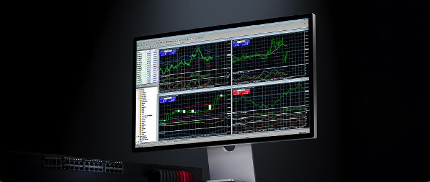 Desktop trading platform on a monitor showing four forex charts and a market watch list