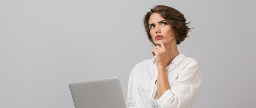 Trader with a laptop thinking about how to choose reliable forex trading signals